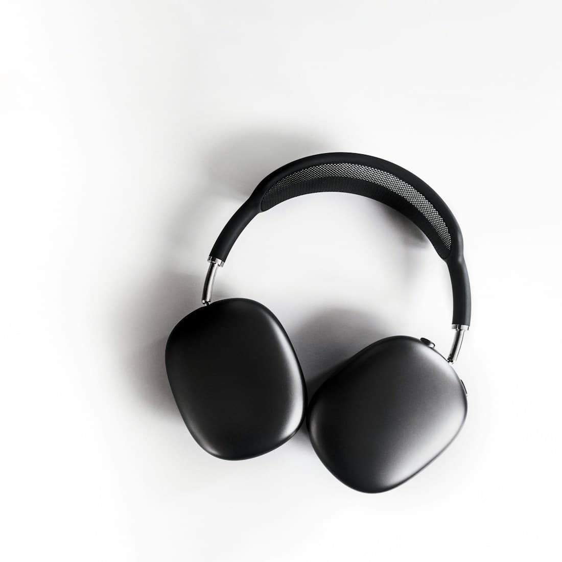 A pair of over-ear headphones resting on a surface
